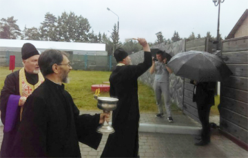 Photofact: Policemen Covering Themselves With Umbrellas To Keep Off Holy Water In Kurapaty