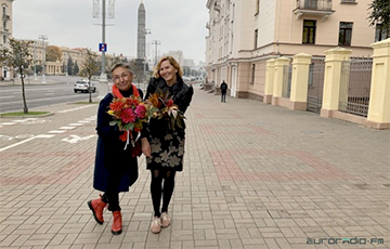 Людзі з кветкамі шпацыруюць па Плошчы Перамогі ў Менску