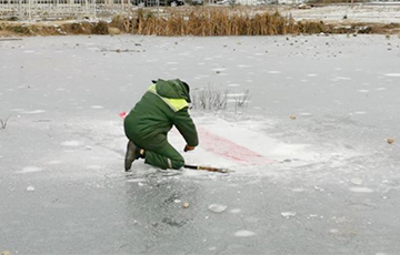 Belarusian Janitors Hollow Out Flags From Under the Ice in the Morning