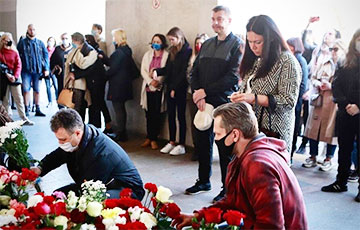Сотни минчан принесли белые и красные цветы к месту трагедии.