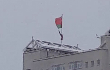 В Минске ветер сначала разорвал, а затем и сорвал красно-зеленый флаг с крыши дома